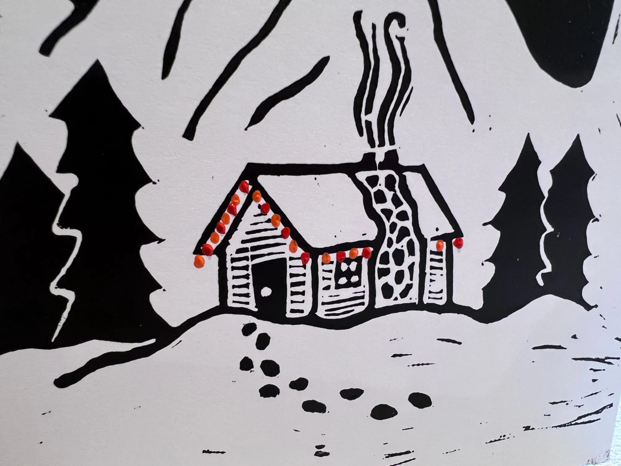 A hand-printed cabin strung with little red and orange lights